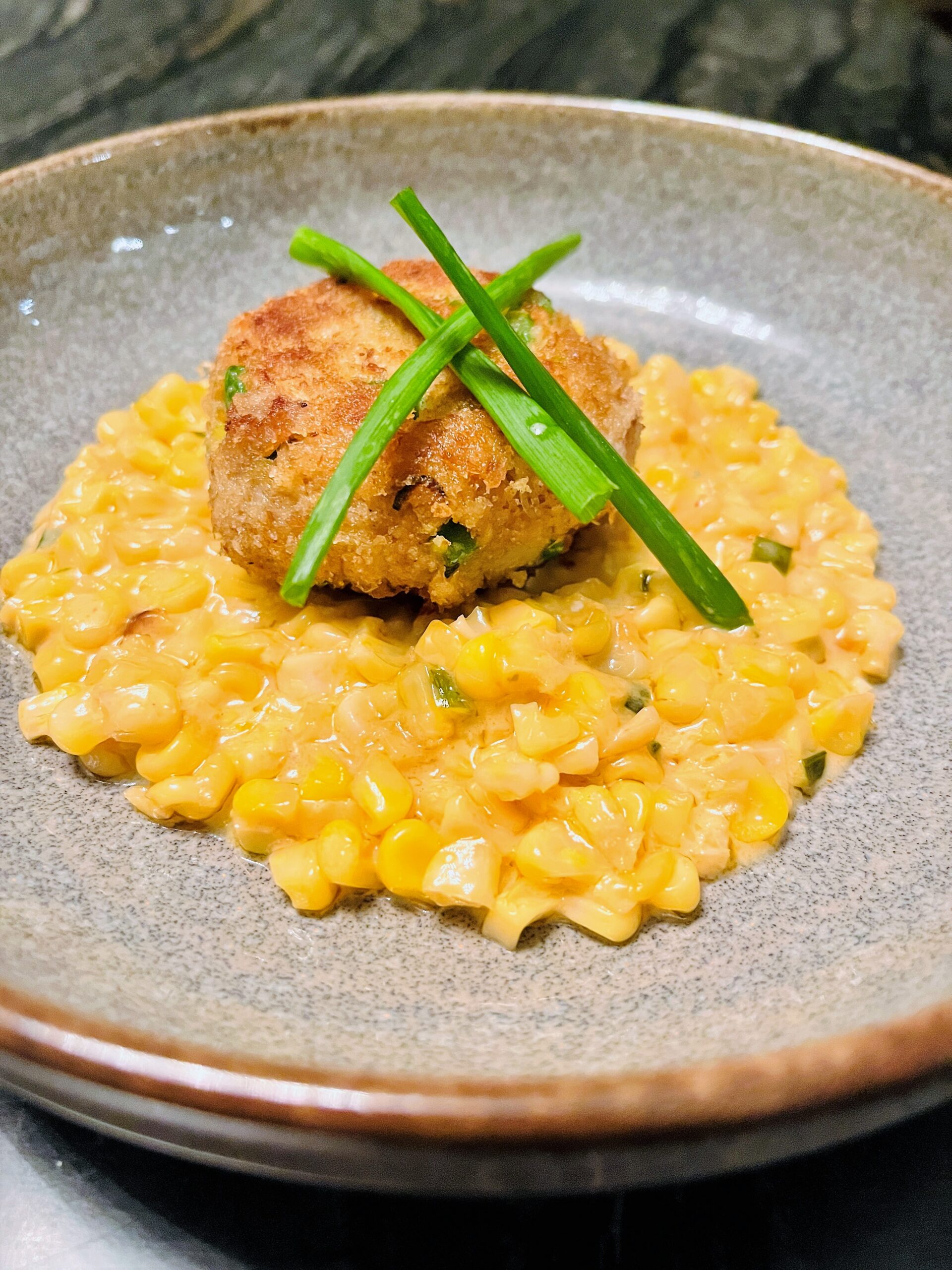 Crab Cake on a bed of Creamed Corn.