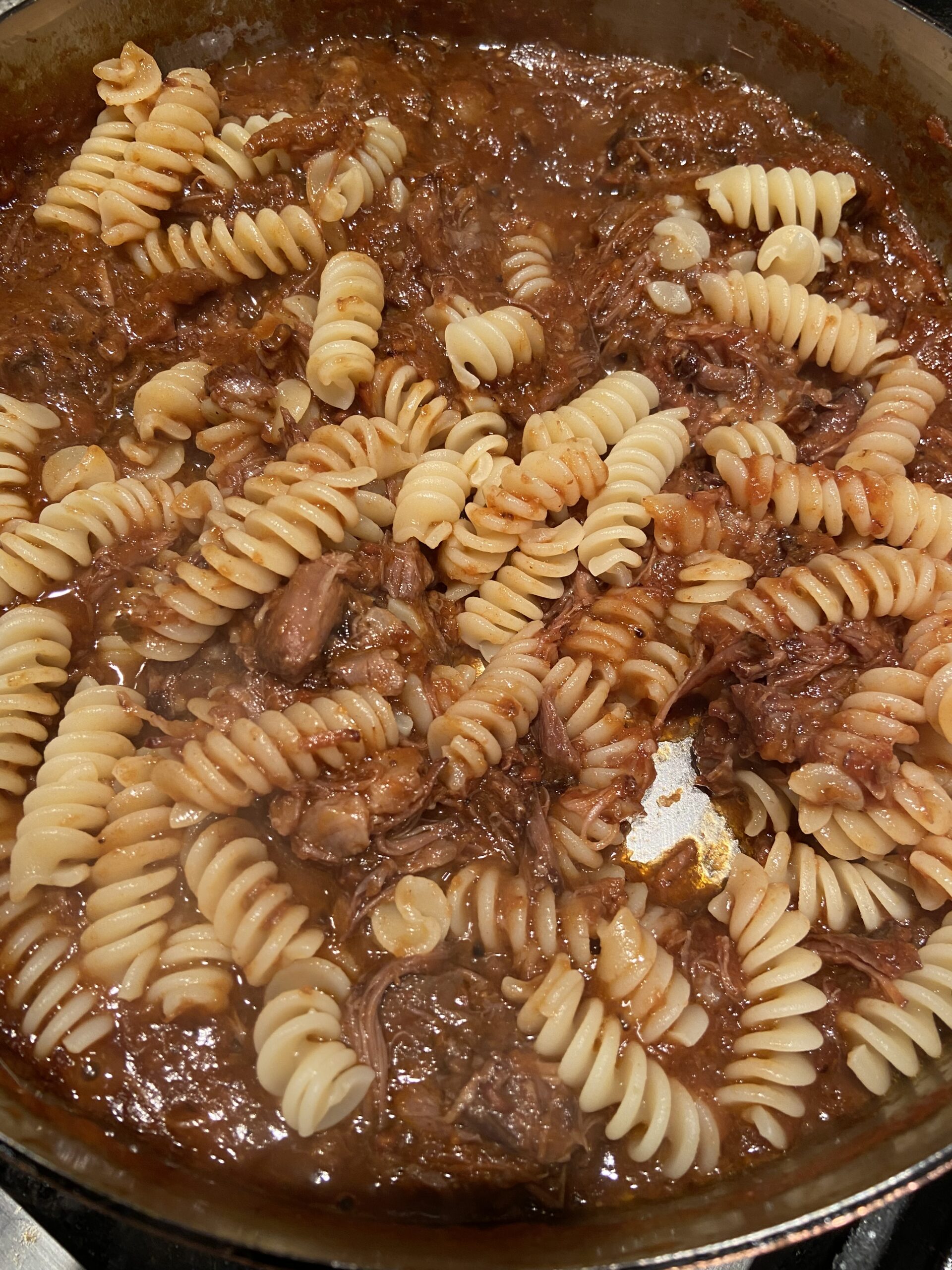 add cooked pasta to the braised oxtail ragu sauce